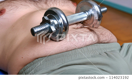 Close-up of a Dumbbell on a Fat Male Belly in the Gym - Generative Ai 114023192