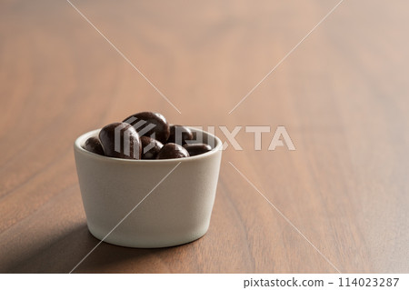 Chocolate covered cashew nuts in a bowl on wood table Chocolate covered cashew nuts in a bowl on wood table 114023287