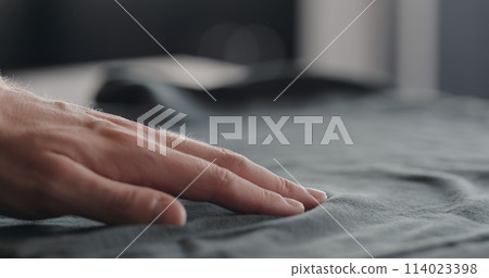 man touching cyan cotton clothes closeup man touching cyan cotton clothes closeup 114023398