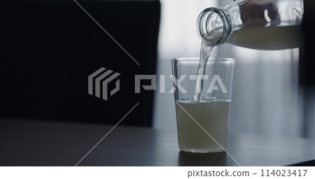 closeup pour lemonade in a tumbler glass on walnut table with copy space closeup pour lemonade in a tumbler glass on walnut table with copy space 114023417