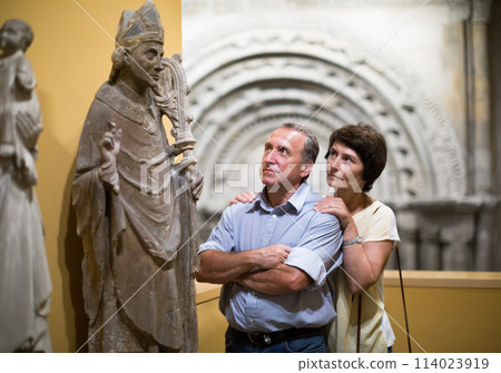 Middle aged men and women collector evaluates the exhibition inl museum 114023919