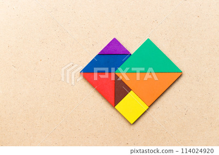 Color tangram puzzle in heart shape on wood table Color tangram puzzle in heart shape on wood table 114024920