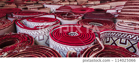 rolled up traditional vintage Uzbek red carpets at oriental bazaar in Uzbekistan 114025066