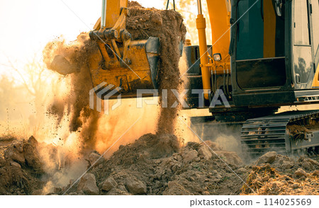 Close-up of excavator at construction site. Backhoe digging soil for earthwork and construction business. Excavating machine at work. Heavy machinery for earth moving and construction site development 114025569