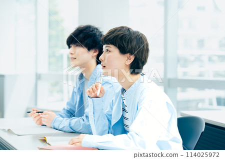 Young men and women receiving a lecture Young men and women receiving a lecture 114025972