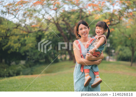 Asian mother walking with daughter in park, Parents hold the baby's in his hand , Happy family in the park evening light. Happy family concept. Asian mother walking with daughter in park, Parents hold the baby's in his hand , Happy family in the park evening light. Happy family concept. 114026818
