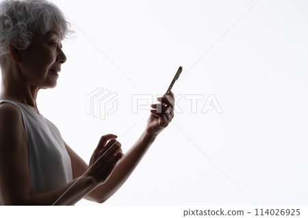 操作智慧型手機的高階女性剪影 114026925