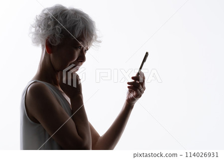 操作智慧型手機的高階女性剪影 114026931