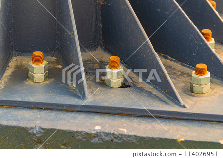 A metal billboard support fixed to a concrete foundation with studs and nuts. Construction, installation of metal structures, types of fasteners 114026951