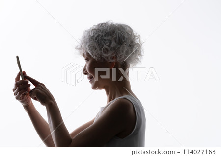 操作智慧型手機的高階女性剪影 114027163