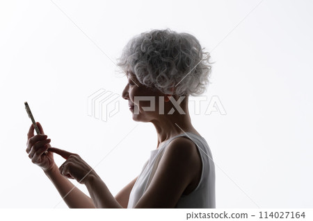 操作智慧型手機的高階女性剪影 114027164