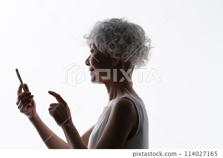 操作智慧型手機的高階女性剪影 114027165