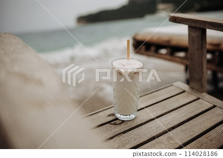 Summer holiday concept. Vintage colours. White coconut ice cream cocktail on wooden chair 114028186