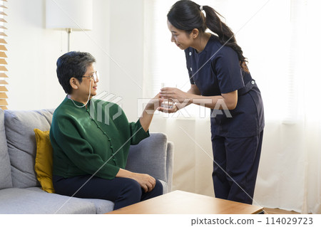 Female asian nurse takes care of old senior woman, help to remind to take a pill. Female asian nurse takes care of old senior woman, help to remind to take a pill. 114029723