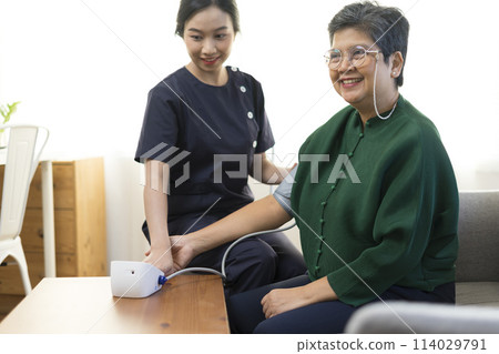 Doctor or nurse using blood pressure gauge with old women patients at Hospitals. 114029791