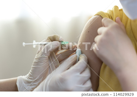 Asian Preteen Girl Getting Vaccinated, Receiving Coronavirus Vaccine Injection in clinic. 114029929