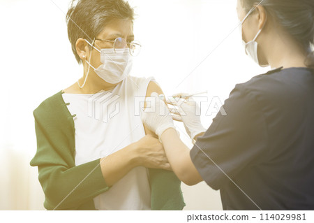 Elderly Asian woman getting coronavirus vaccine by nurse. Medical worker prepare syringe. 114029981