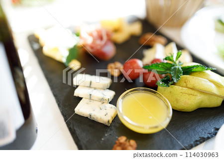 Cheese plate. Gorgonzola, hard cheese, grapes, honey, nuts 114030963