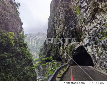 Taroko, Taiwan - 11.26.2022: Swallow Grotto Trail with no people passing through marble cliffs in the narrow Liwu River gorge in the mist before the 403 earthquake during the pandemic on a rainy day Taroko, Taiwan - 11.26.2022: Swallow Grotto Trail with no people passing through marble cliffs in the narrow Liwu River gorge in the mist before the 403 earthquake during the pandemic on a rainy day 114031307