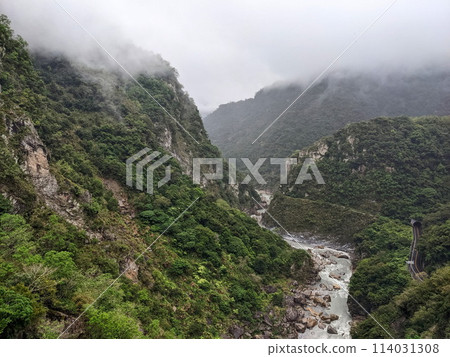 Taroko, Taiwan - 11.26.2022: Central Cross-Island Highway in Liwu River Gorge along cliffs and trees with mountains covered in mist, view from Buluowan Cable Suspension Bridge before 403 earthquake Taroko, Taiwan - 11.26.2022: Central Cross-Island Highway in Liwu River Gorge along cliffs and trees with mountains covered in mist, view from Buluowan Cable Suspension Bridge before 403 earthquake 114031308