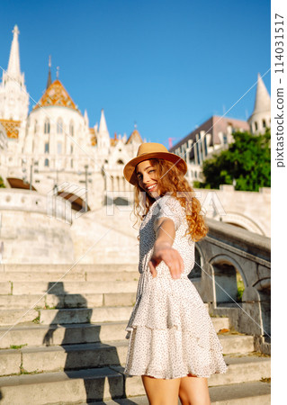 Happy young woman in hat at dawn enjoys view of beautiful buildings. Lifestyle, recreation concept. Happy young woman in hat at dawn enjoys view of beautiful buildings. Lifestyle, recreation concept. 114031517
