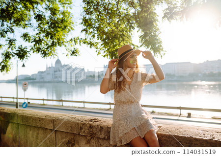 A beautiful young woman walks on the embankment. Tourism relax, youth, nature. 114031519