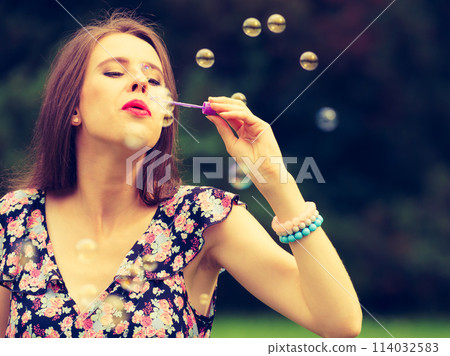 Woman blowing soap bubbles, having fun 114032583