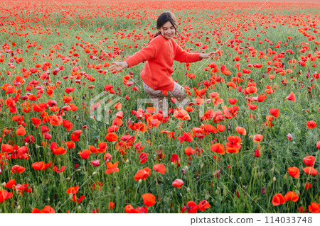 girl in red clothes dancing in the middle of the poppy field 114033748
