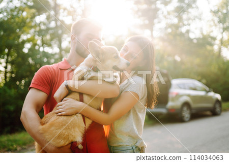 Young couple together with their beloved pet on walk. Domestic dog concept. Active lifestyle concept Young couple together with their beloved pet on walk. Domestic dog concept. Active lifestyle concept 114034063