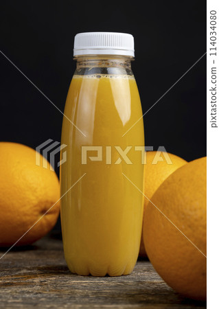 peeled juicy oranges and orange juice on the table 114034080
