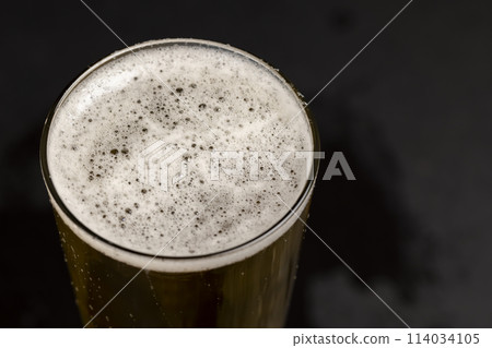 a glass glass with an alcoholic drink in close-up 114034105