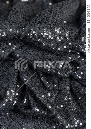 a large number of sequins on a black material a large number of sequins on a black material 114034191