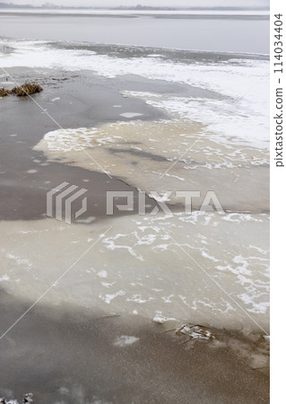 frozen lake in winter in cloudy weather, ice on the lake ts 114034404