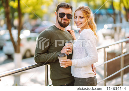 Happy couple spending time together drinking coffee having fun walking around morning city Lifestyle 114034544
