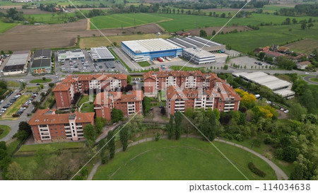 Aerial view Apartments in residential complex and Industrial zone. Top view of the city San Giuliano Milanese. Drone view of houses and streets on a spring day. Milan, Lombardy, Italy. 114034638