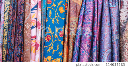 Traditional silk Uzbek scarves with colorful pattern at oriental bazaar in Tashkent in Uzbekistan close-up 114035283