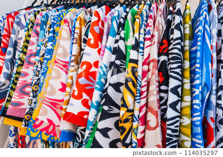 Asian dresses made of silk fabric with bright colorful pattern at oriental bazaar in India close-up 114035297
