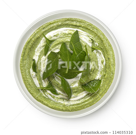 Spinach cream soup with leaves isolated on white background. Top view 114035310