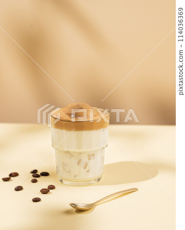Vegan dalgona coffee. Whipped instant iced coffee with soy milk in a glass on yellow background 114036369