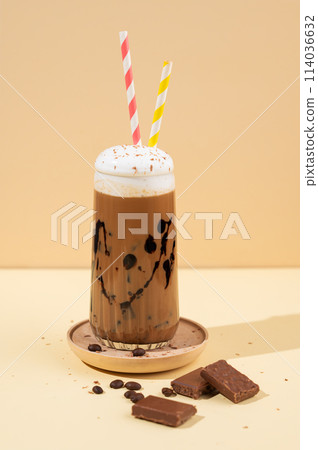 Cold chocolate coffee drink or milkshake with whipped cream in a tall glass  114036632