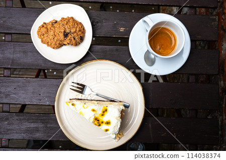 High angle view of coockies, cheesecake and a cup of coffee on a wooden table, Belgium High angle view of coockies, cheesecake and a cup of coffee on a wooden table, Belgium 114038374