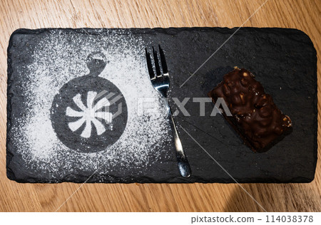 Katowice, Silesian, Poland,  Decorated chocolate cake with peanuts, served with a sugar decoration on a black plate, Brussels, Belgium 114038378