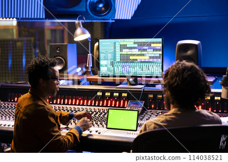 Musician and sound producer look at isolated mockup on tablet, using mixing and mastering techniques to create songs. Musicians team editing music with digital audio software app. Musician and sound producer look at isolated mockup on tablet, using mixing and mastering techniques to create songs. Musicians team editing music with digital audio software app. 114038521