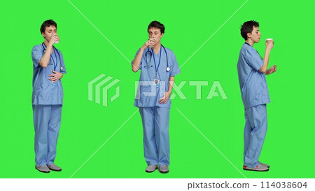 Healthcare specialist enjoying hot coffee cup against greenscreen backdrop, drinking caffeine refreshment in blue scrubs. Medical assistant serving beverage at work, friendly staff. Camera A. Healthcare specialist enjoying hot coffee cup against greenscreen backdrop, drinking caffeine refreshment in blue scrubs. Medical assistant serving beverage at work, friendly staff. Camera A. 114038604