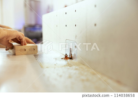 Carpenter using wood shaper machinery to finish client commissioned work on wooden objects in studio. Woodworking expert in joinery shop using spindle moulder equipment to do furniture assembling 114038658