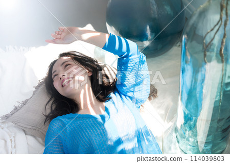 A beautiful woman lying down in the dazzling summer sunshine. Also great for beauty images of the beach, summer tans, and UV rays. A beautiful woman lying down in the dazzling summer sunshine. Also great for beauty images of the beach, summer tans, and UV rays. 114039803