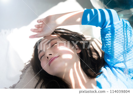 A beautiful woman lying down in the dazzling summer sunshine with her eyes closed. Also great for beauty images of the beach, summer tans, and UV rays. A beautiful woman lying down in the dazzling summer sunshine with her eyes closed. Also great for beauty images of the beach, summer tans, and UV rays. 114039804