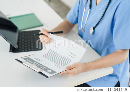 Healthcare Professional Reviewing Medical Documents. 114041349
