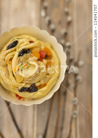 raw kraffin kulich with candied fruit on wooden table with sprigs of willow top view raw kraffin kulich with candied fruit on wooden table with sprigs of willow top view 114041707