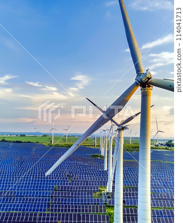 Windmills and solar panels against the blue sky 114041713